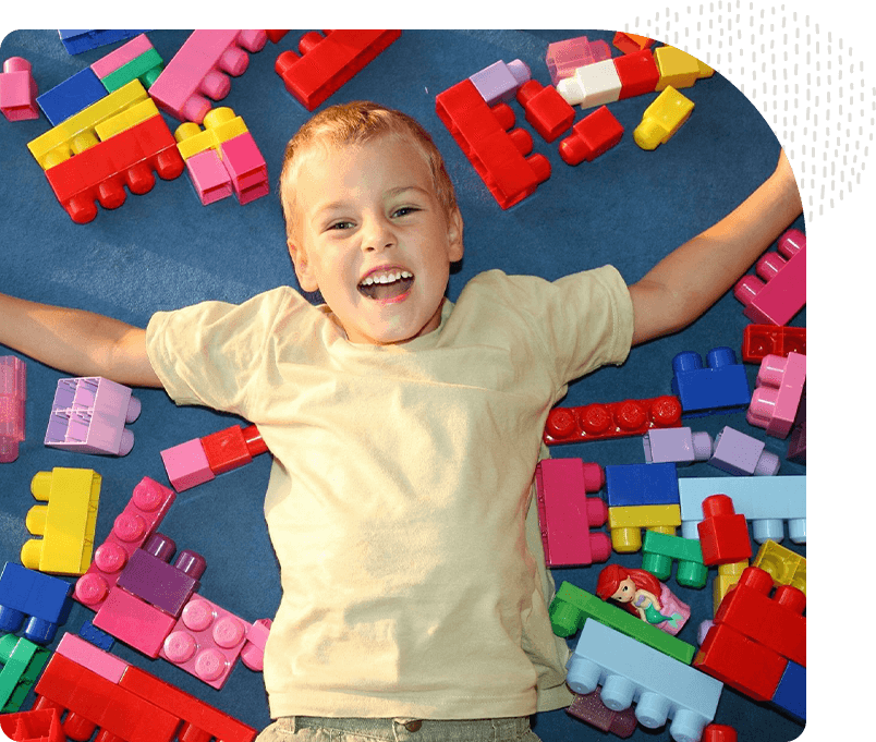 A boy laying on the ground with many blocks