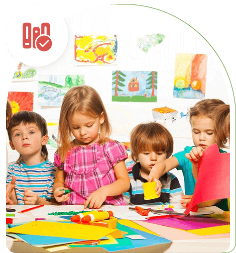 A group of children sitting at a table with paper.